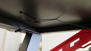 Stick the included wire-management zip-ties to the underside of the desk in one . . .